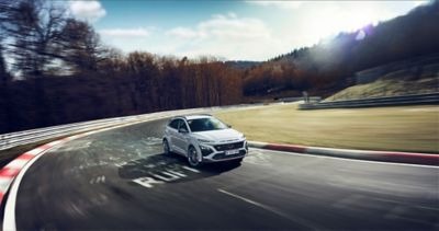 Nový Hyundai KONA N vo farbe Sonic Blue jazdiaci po pretekovom okruhu.